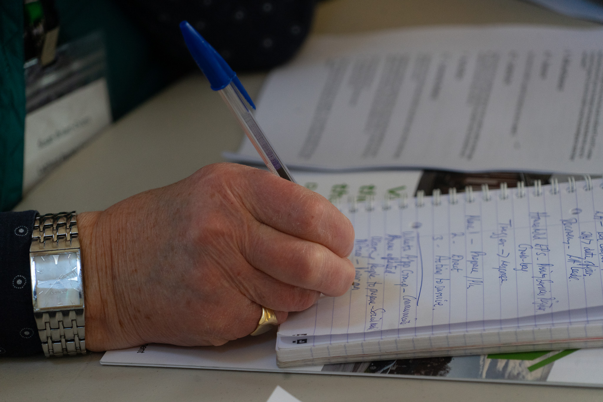 Hand taking notes at a conference