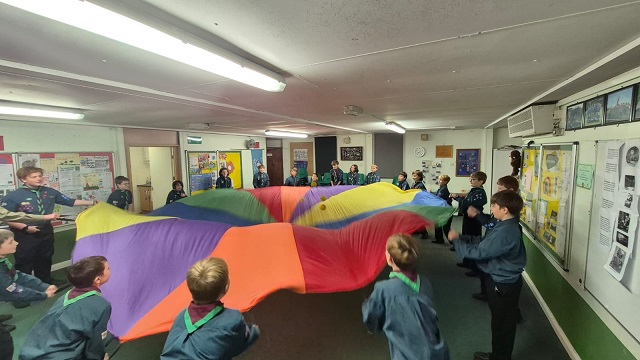 Group of children playing with a colourful parachute