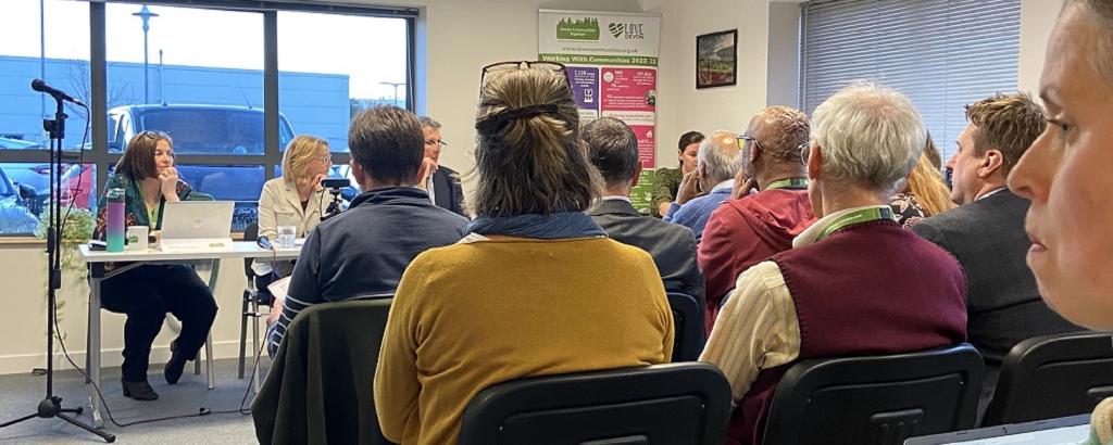 DCT AGM 2023 - backs of audience heads, seated, facing a seated panel of people