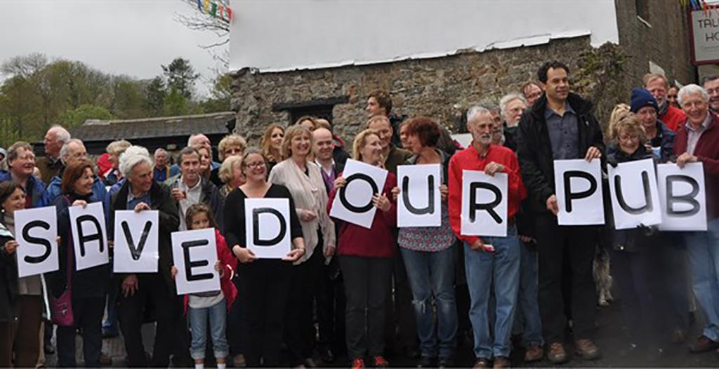 People in a line holding letters which spell "SAVED OUR PUB"