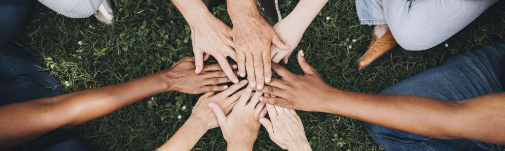 group of people with there hands in the middle