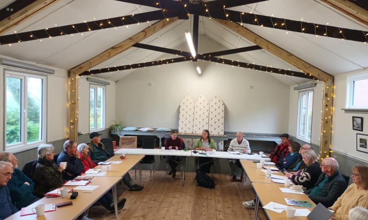 East Devon VH cluster meeting, smiling people sat in a village hall 