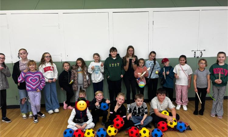 Group of children in a sports hall with foam balls