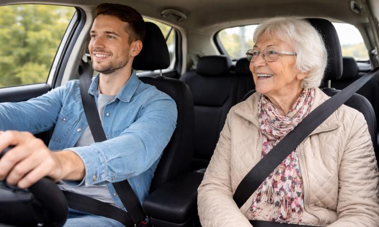 young male driver sitting next to an older female passenger